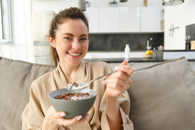 Jovem sorrindo ao comer cereal, aproveitando a liberdade alimentar do tratamento com alinhador Clearcorrect em Cruz Alta - RS.